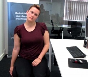 Picture of a women doing neck exercises from her desk.